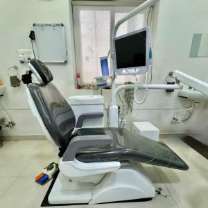 Modern dental treatment chair with attached monitor and dental instruments in a clinical room ready for patient care
